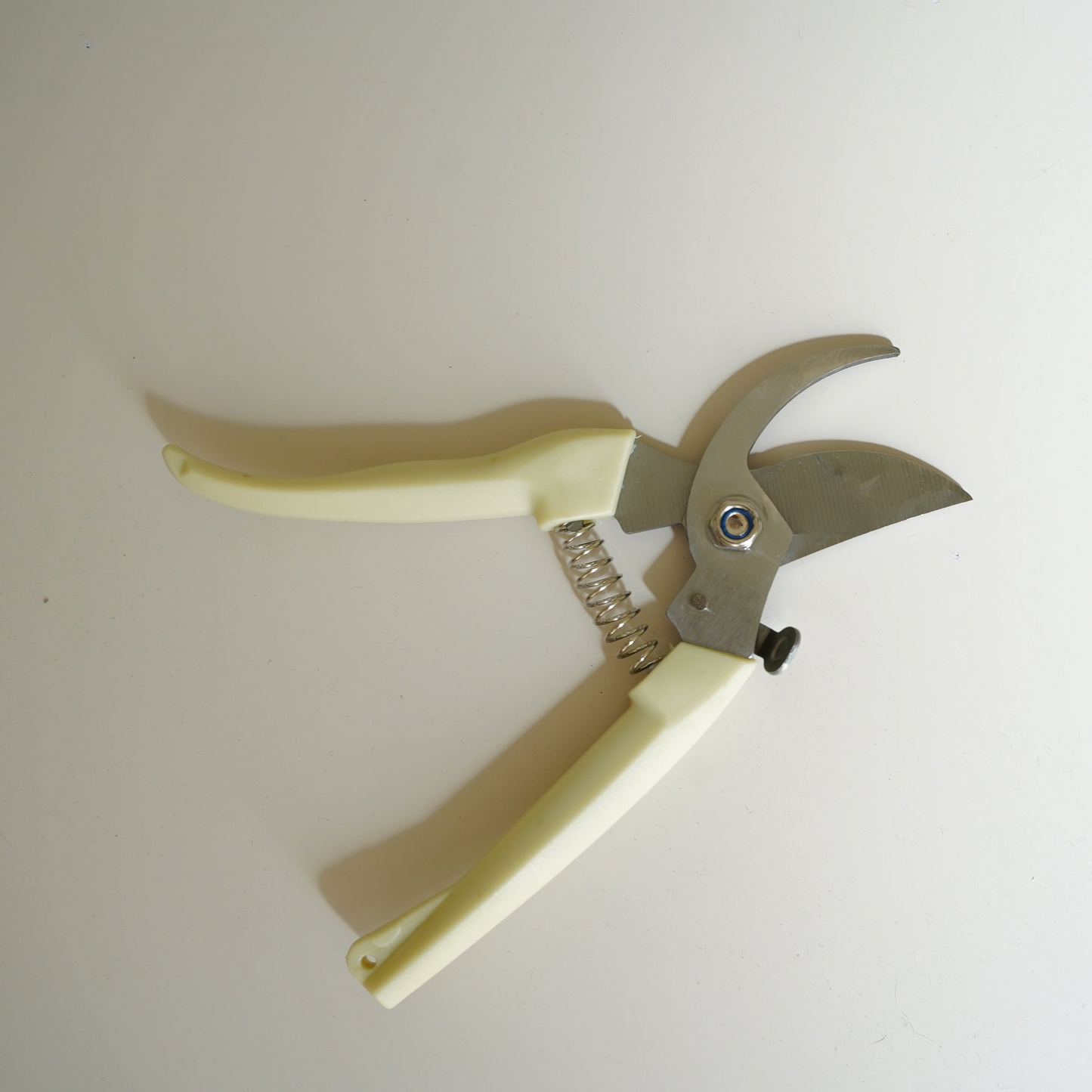 Garden pruner with beige handle on a white background