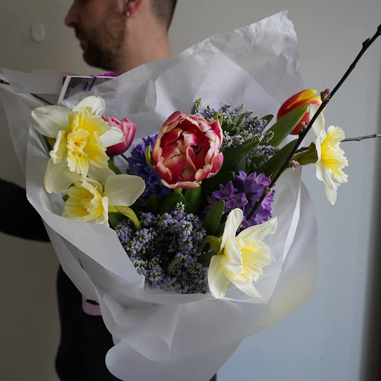Seasonal pastel bouquet with narcissus tulips and hyacinths minimalist wrapping Lisbon