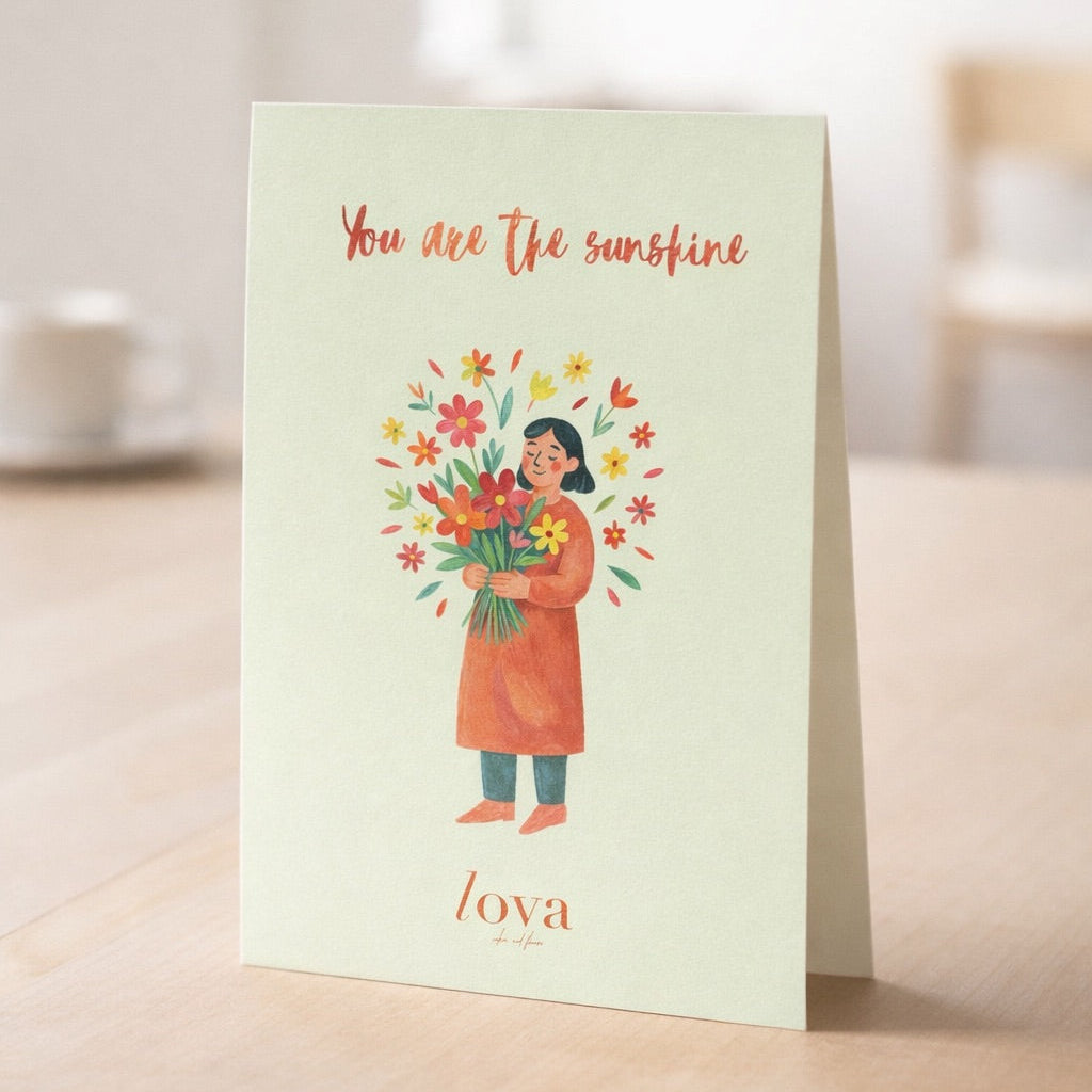 Greeting card with illustration of a person holding flowers and text 'You are the sunshine' on a light green background.