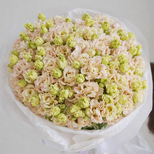 Peach lisianthus bouquet with green buds wrapped in white paper, elegant flower delivery Lisbon