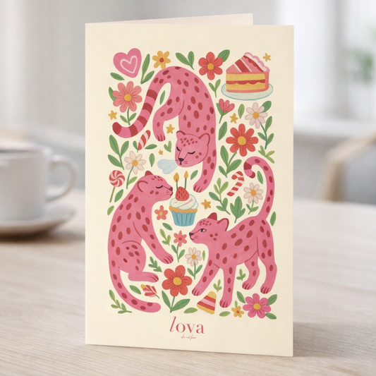 Greeting card with pink panthers and flowers on a table with a cup and saucer.