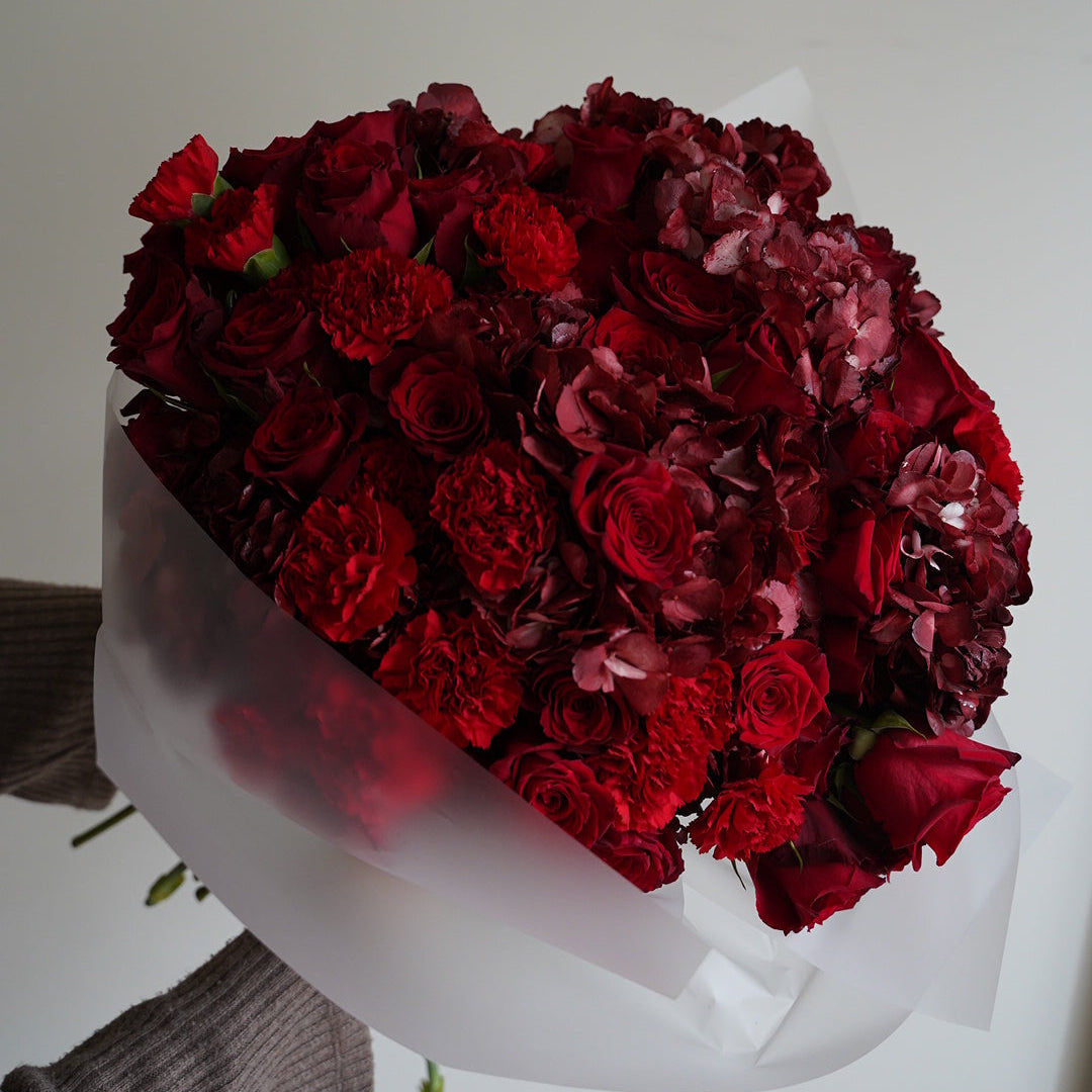 Red roses and hydrangea bouquet wrapped in white paper, elegant flower gift Portugal