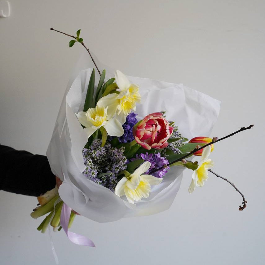 Spring bouquet with daffodils tulips and hyacinths wrapped in white paper, seasonal flower delivery Lisbon