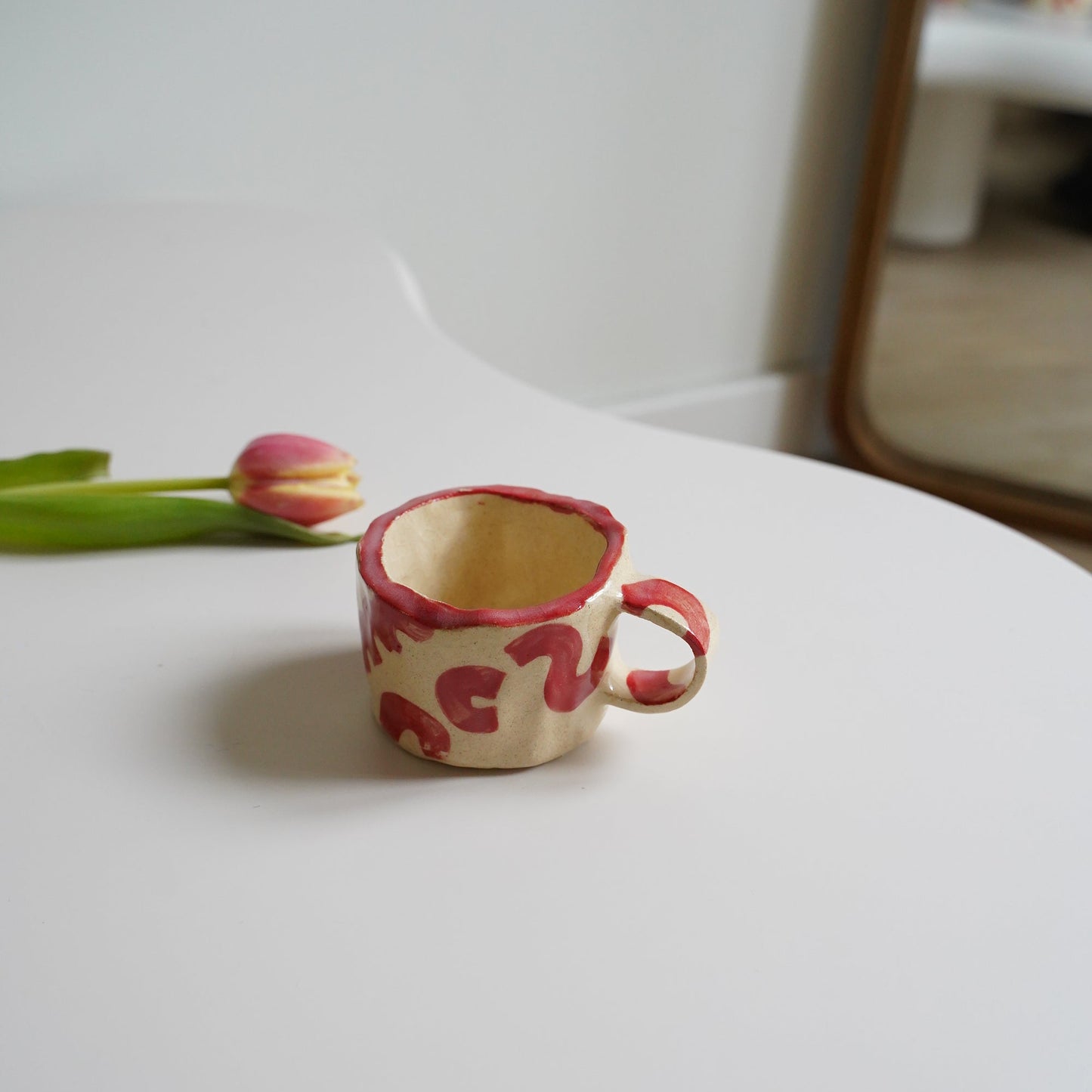 Decorative cup with floral design attached to a white surface