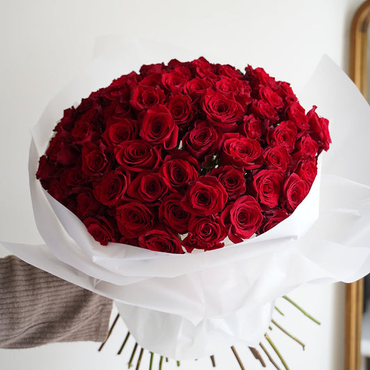 Large bouquet of red roses with 51 stems, lush romantic roses wrapped in white paper